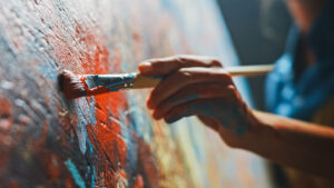 Close-up of a painting with a hand holding paintbrush
